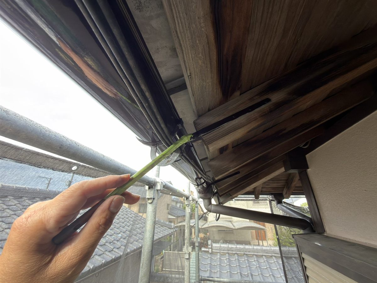 軒先の木の板が灰色っぽく色あせ、黒ずんでいる様子