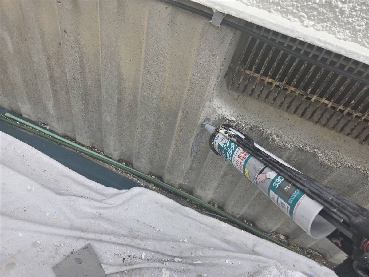 建物の基礎のひび割れに、補修材を充填している様子
